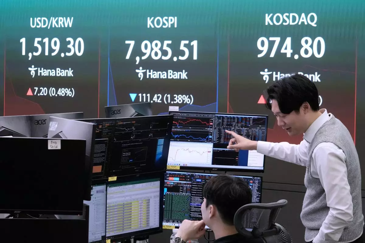 Currency traders work near a screen showing the Korea Composite Stock Price Index (KOSPI) and the foreign exchange rate between U.S. dollar and South Korean won at the foreign exchange dealing room of the Hana Bank headquarters in Seoul, South Korea, Wednesday, June 10, 2026. (AP Photo/Ahn Young-joon)