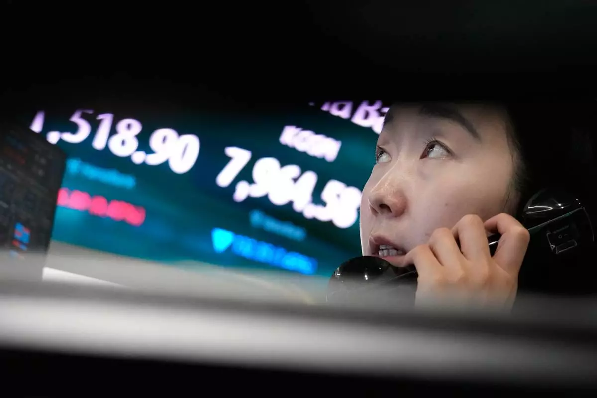 A currency trader talks on the phone near a screen showing the Korea Composite Stock Price Index (KOSPI) and the foreign exchange rate between U.S. dollar and South Korean won at the foreign exchange dealing room of the Hana Bank headquarters in Seoul, South Korea, Wednesday, June 10, 2026. (AP Photo/Ahn Young-joon)