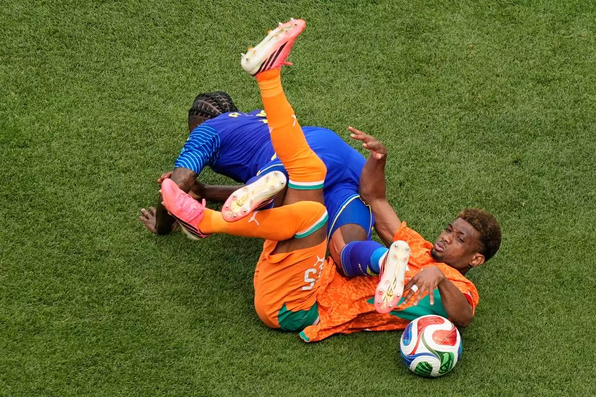 Curaçao's Sherel Floranus (5) tackles Ivory Coast's Amad Diallo (15) during the World Cup Group E soccer match between Curacao and Ivory Coast in Philadelphia, Thursday, June 25, 2026. (AP Photo/Matt Slocum)