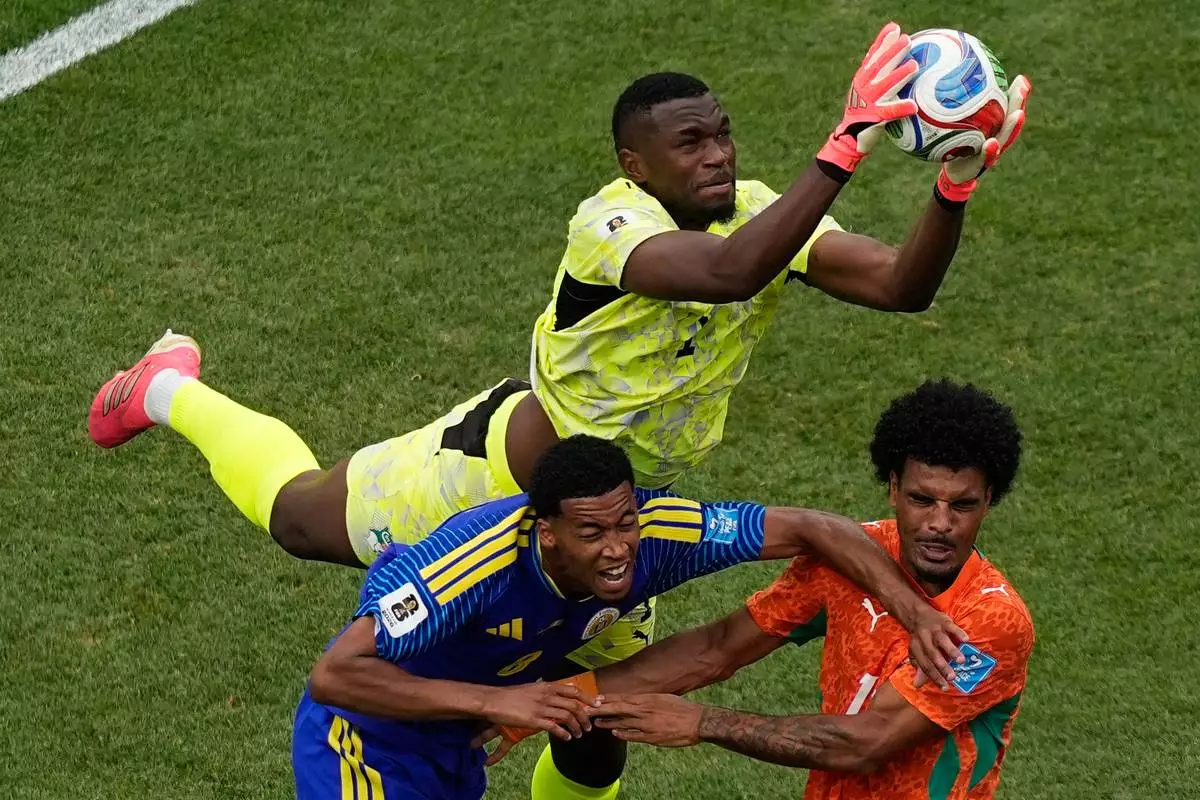 Ivory Coast goalkeeper Yahia Fofana (1) makes a save in front of Curaçao's Livano Comenencia (8) and Ivory Coast's Christopher Operi (13) during the World Cup Group E soccer match between Curacao and Ivory Coast in Philadelphia, Thursday, June 25, 2026. (AP Photo/Matt Slocum)
