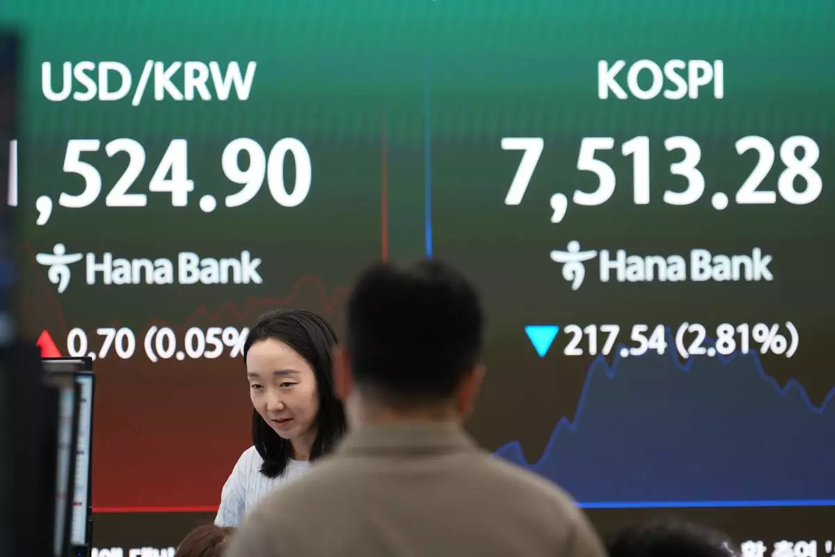 Dealers talk near a screen showing the Korea Composite Stock Price Index (KOSPI) and a foreign exchange rate between the U.S. dollar and the South Korean won at a dealing room of Hana Bank in Seoul, South Korea, Thursday, June 11, 2026. (AP Photo/Lee Jin-man)