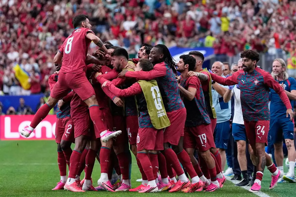 Portugal players celebrate after Cristiano Ronaldo scored the opening goal during the World Cup Group K soccer match between Portugal and Uzbekistan in Houston, Tuesday, June 23, 2026. (AP Photo/Ashley Landis)