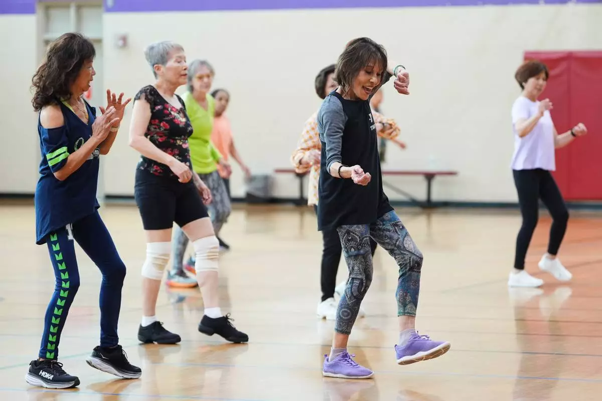 Instructor Bengie Santos, 72, leads a class for older adults, including Pilar Madayag, left, at the Dale Turner Family YMCA, April 30, 2026, in Shoreline, Wash. (AP Photo/Lindsey Wasson)