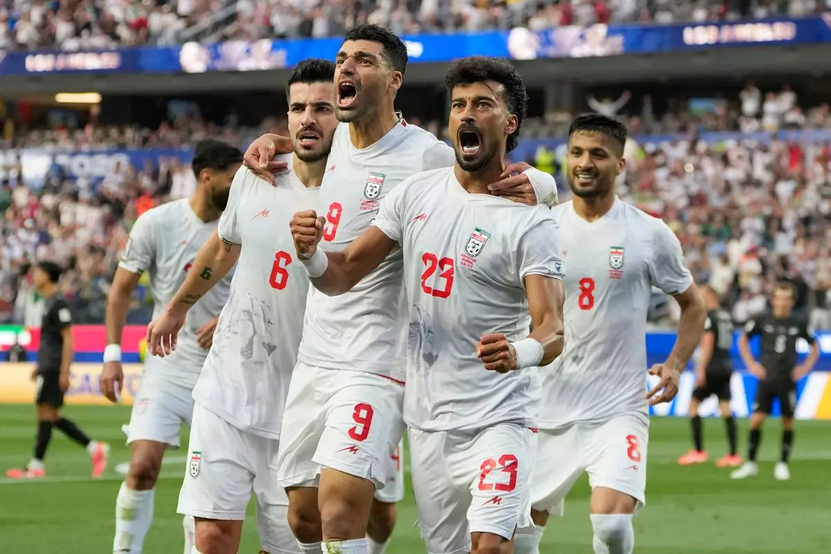 Iran's Ramin Rezaeian (23) celebrates with his teammates after scoring a goal during the World Cup Group G soccer match between Iran and New Zealand in Inglewood, Calif., near Los Angeles, Monday, June 15, 2026. (AP Photo/Andre Penner)