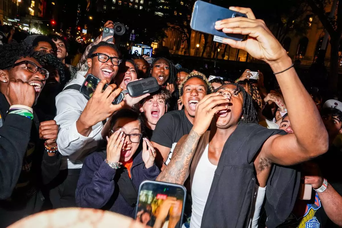 New York Knicks fans watch Game 3 of the NBA Finals basketball series on a smartphone outside of a watch party in Bryant Park, Monday, June 8, 2026, in New York. (AP Photo/Ryan Murphy)