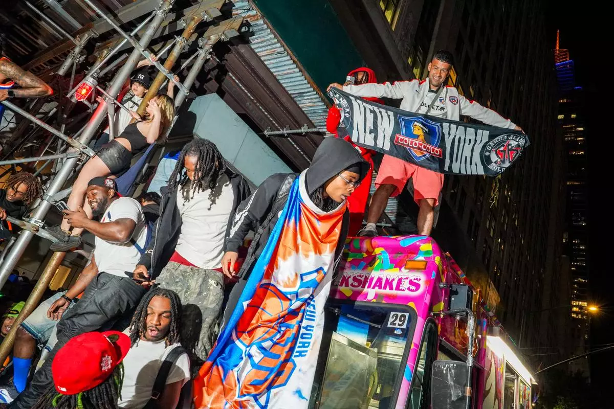 New York Knicks fans celebrate on the street outside of a watch party in Bryant Park for Game 3 of the NBA Finals basketball series between the Knicks and the San Antonio Spurs, Monday, June 8, 2026, in New York. (AP Photo/Ryan Murphy)