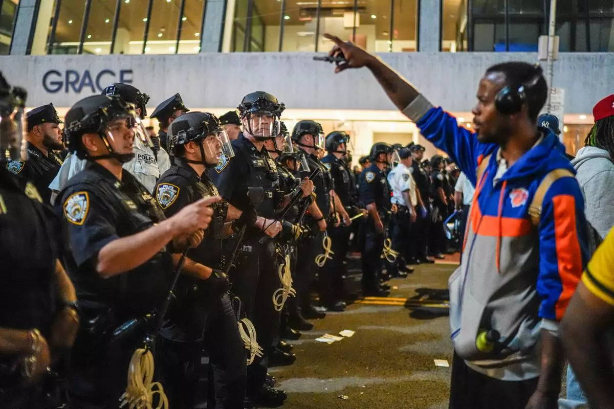 NYPD officers push New York Knicks fans back outside of a watch party in Bryant Park for Game 3 of the NBA Finals basketball series between the Knicks and the San Antonio Spurs, Monday, June 8, 2026, in New York. (AP Photo/Ryan Murphy)