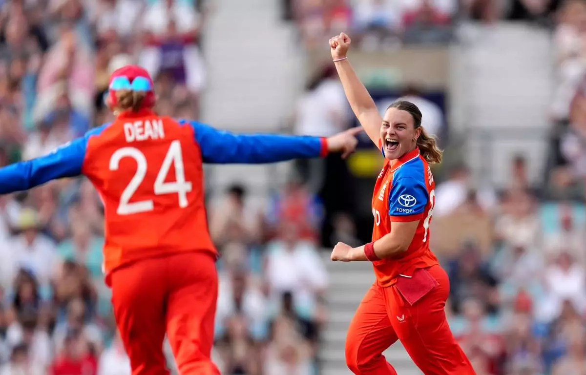 England's Dani Gibson, right, celebrates after taking the wicket of New Zealand's Izzy Sharp during the Women's T20 World Cup cricket match between England and New Zealand at The Kia Oval in London, Saturday June 27, 2026. (Ben Whitley/PA via AP)