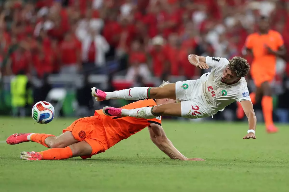 Morocco's Neil El Aynaoui (24) falls as Netherlands' Jan Paul van Hecke (6) slides under him during the World Cup round of 32 soccer match between the Netherlands and Morocco in Guadalupe, near Monterrey, Mexico, Monday, June 29, 2026. (AP Photo/Sofia Yaker)