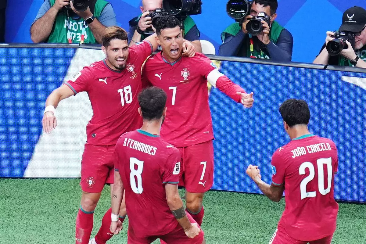 Portugal's Cristiano Ronaldo (7) celebrates with Portugal's Pedro Neto (18), Portugal's Bruno Fernandes (8) and Portugal's Joao Cancelo (20) after scoring his side's third goal during the World Cup Group K soccer match between Portugal and Uzbekistan in Houston, Tuesday, June 23, 2026. (AP Photo/Karen Warren)