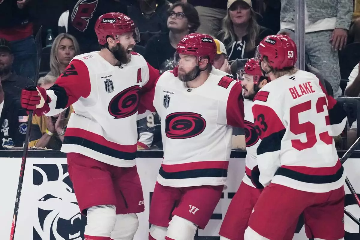 Carolina Hurricanes left wing Taylor Hall, center, celebrates his goal with teammates during the first period in Game 6 of the NHL hockey Stanley Cup Final series against the Vegas Golden Knights, Sunday, June 14, 2026, in Las Vegas. (AP Photo/John Locher)