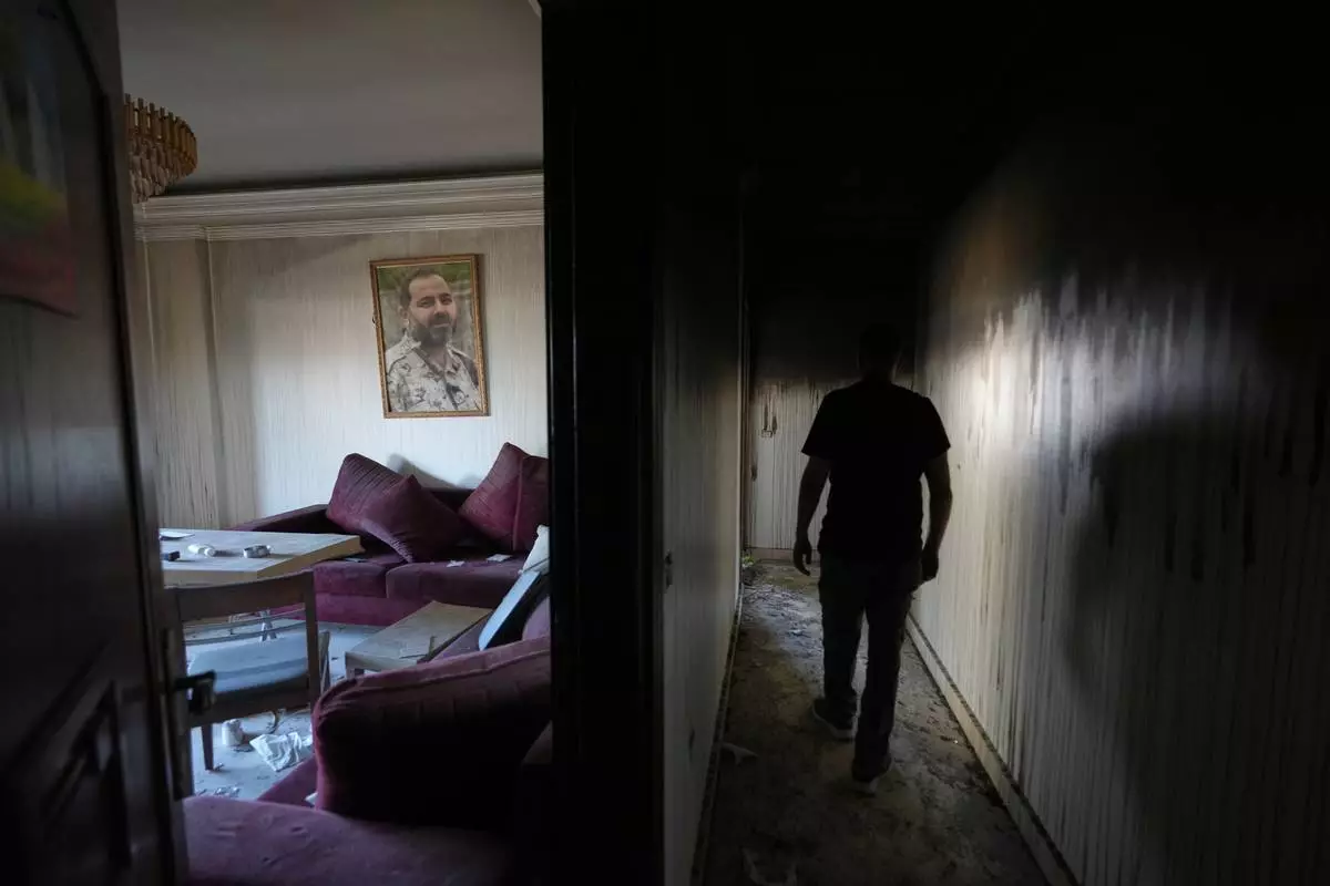 Resident Samih Haidar inspects his burned apartment damaged in Israeli strikes in the southern port city of Tyre, Lebanon, Thursday, June 18, 2026. (AP Photo/Hassan Ammar)