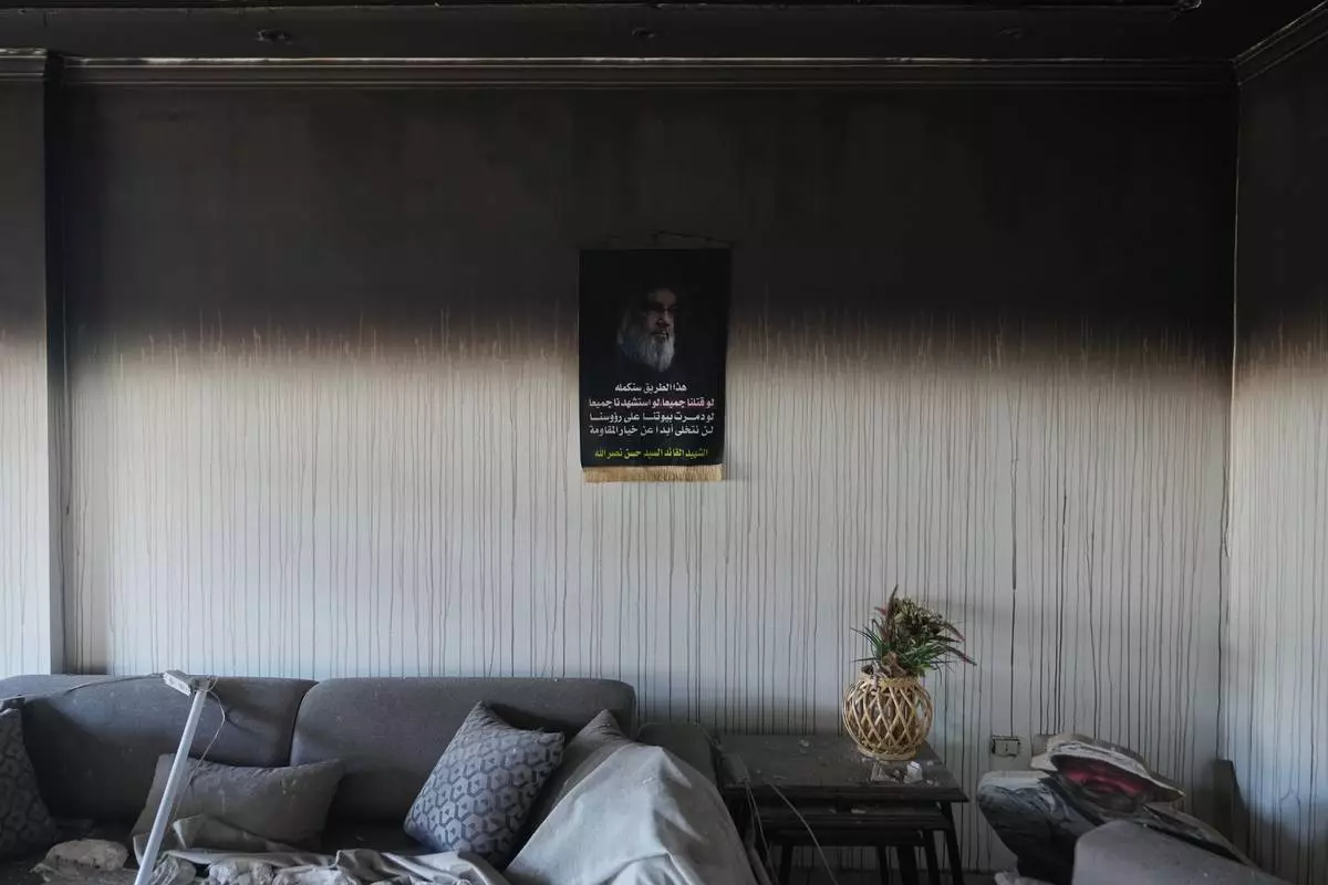 A portrait of former Hezbollah leader Hassan Nasrallah hangs on a wall inside a burned apartment damaged in Israeli strikes in the southern port city of Tyre, Lebanon, Thursday, June 18, 2026. (AP Photo/Hassan Ammar)