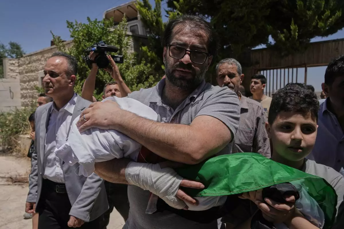 Fahd Abu Haikal, 41 carries the body of his seven month old Palestinian baby boy Sam, who was killed on Friday when, according to the Palestinian health ministry, Israeli soldiers fired at the vehicle carrying him and his parents in Tel Rumeida, during his funeral in the West Bank city of Hebron, Saturday, June 6, 2026. (AP Photo/Mahmoud Illean)