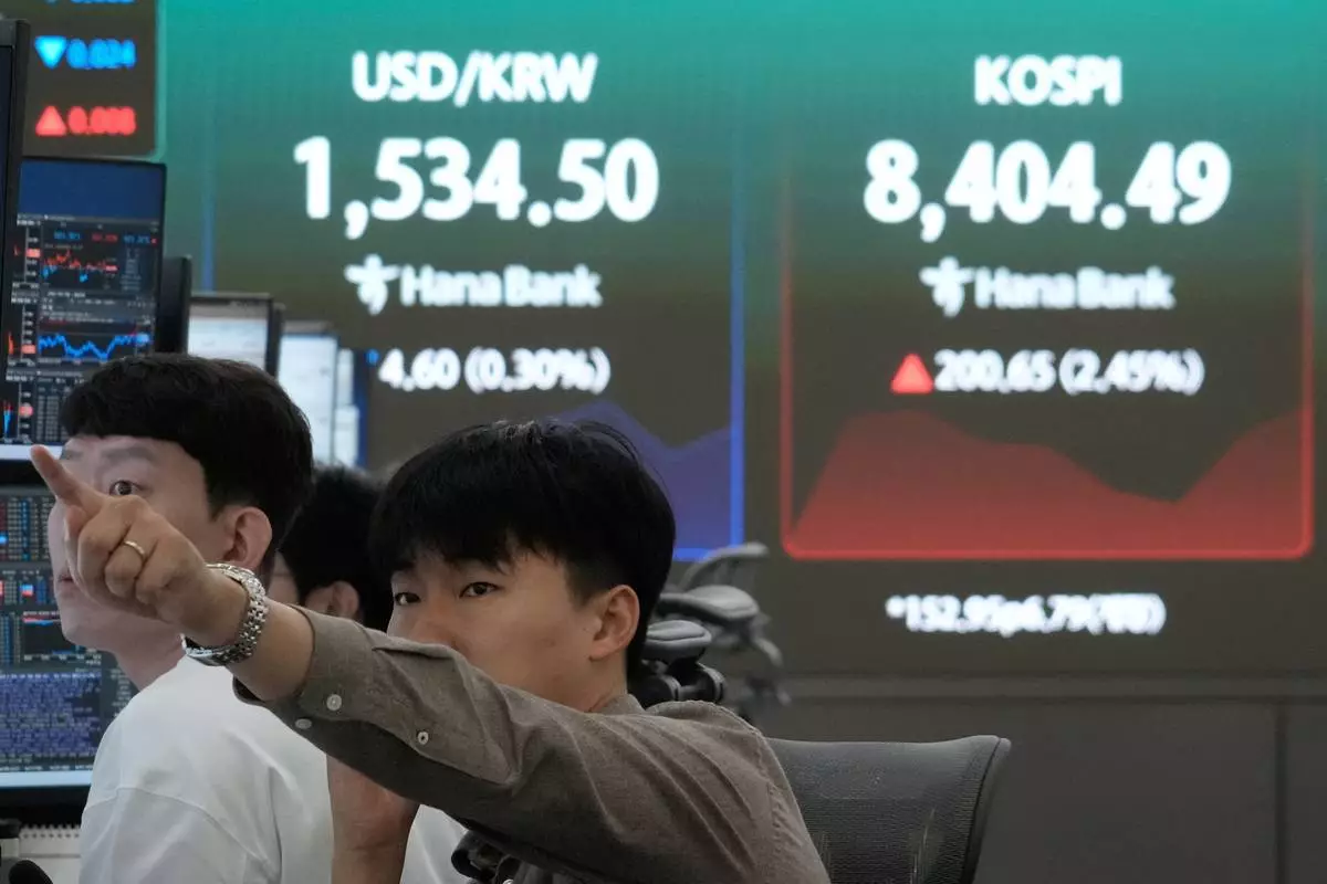 A currency trader watches monitors near a screen showing the Korea Composite Stock Price Index (KOSPI) and the foreign exchange rate between U.S. dollar and South Korean won at the foreign exchange dealing room of the Hana Bank headquarters in Seoul, South Korea, Wednesday, June 24, 2026. (AP Photo/Ahn Young-joon)