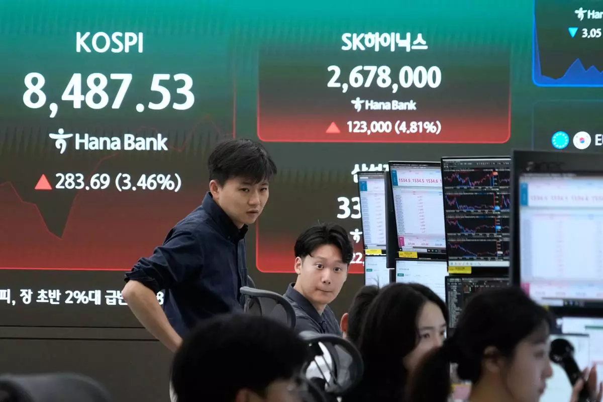 Currency traders work near a screen showing the Korea Composite Stock Price Index (KOSPI) at the foreign exchange dealing room of the Hana Bank headquarters in Seoul, South Korea, Wednesday, June 24, 2026. (AP Photo/Ahn Young-joon)