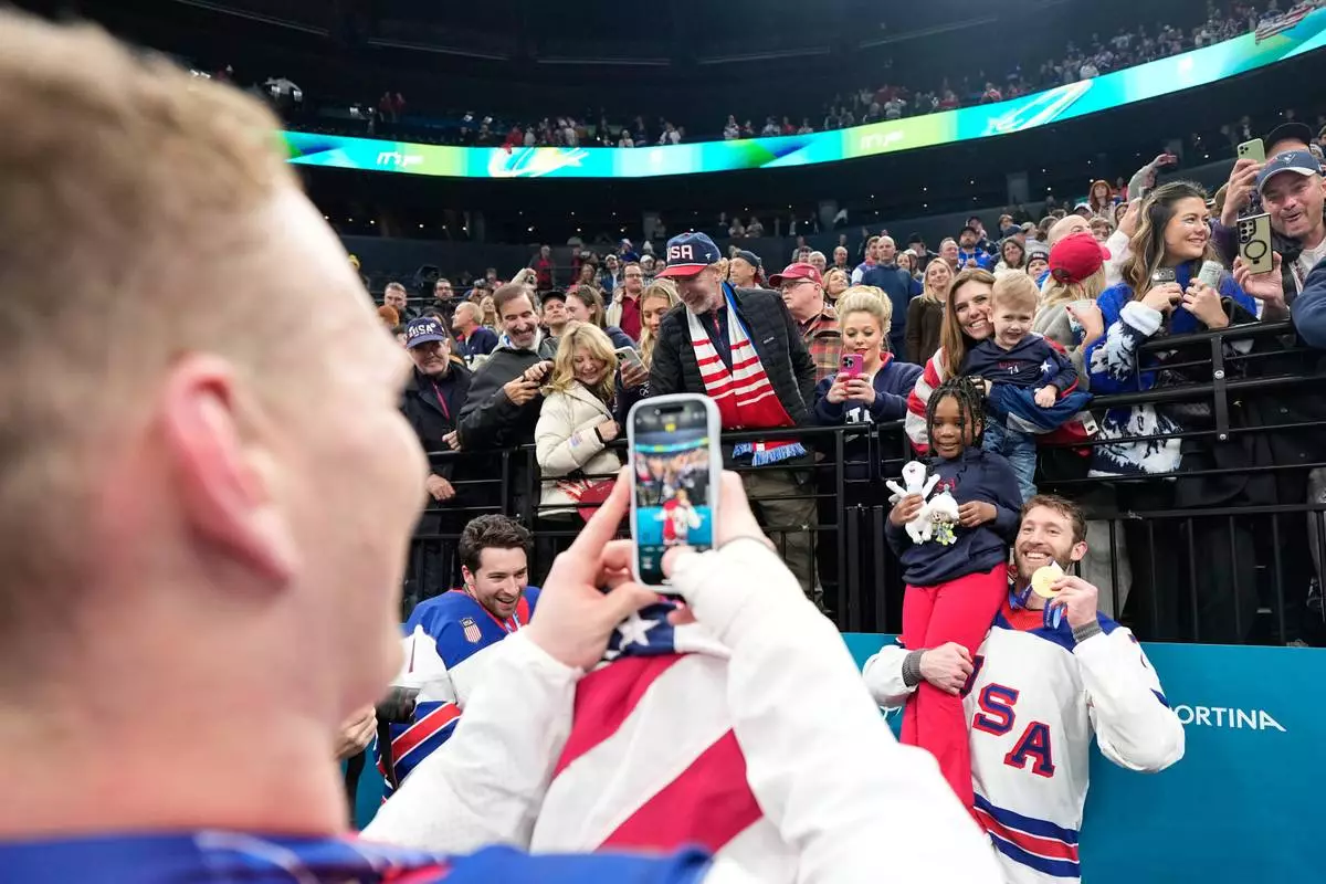 FILE - United States' Jaccob Slavin (74) poses with his gold medal after the men's ice hockey gold medal game between Canada and the United States at the 2026 Winter Olympics, in Milan, Italy, Feb. 22, 2026. (AP Photo/Hassan Ammar, File)