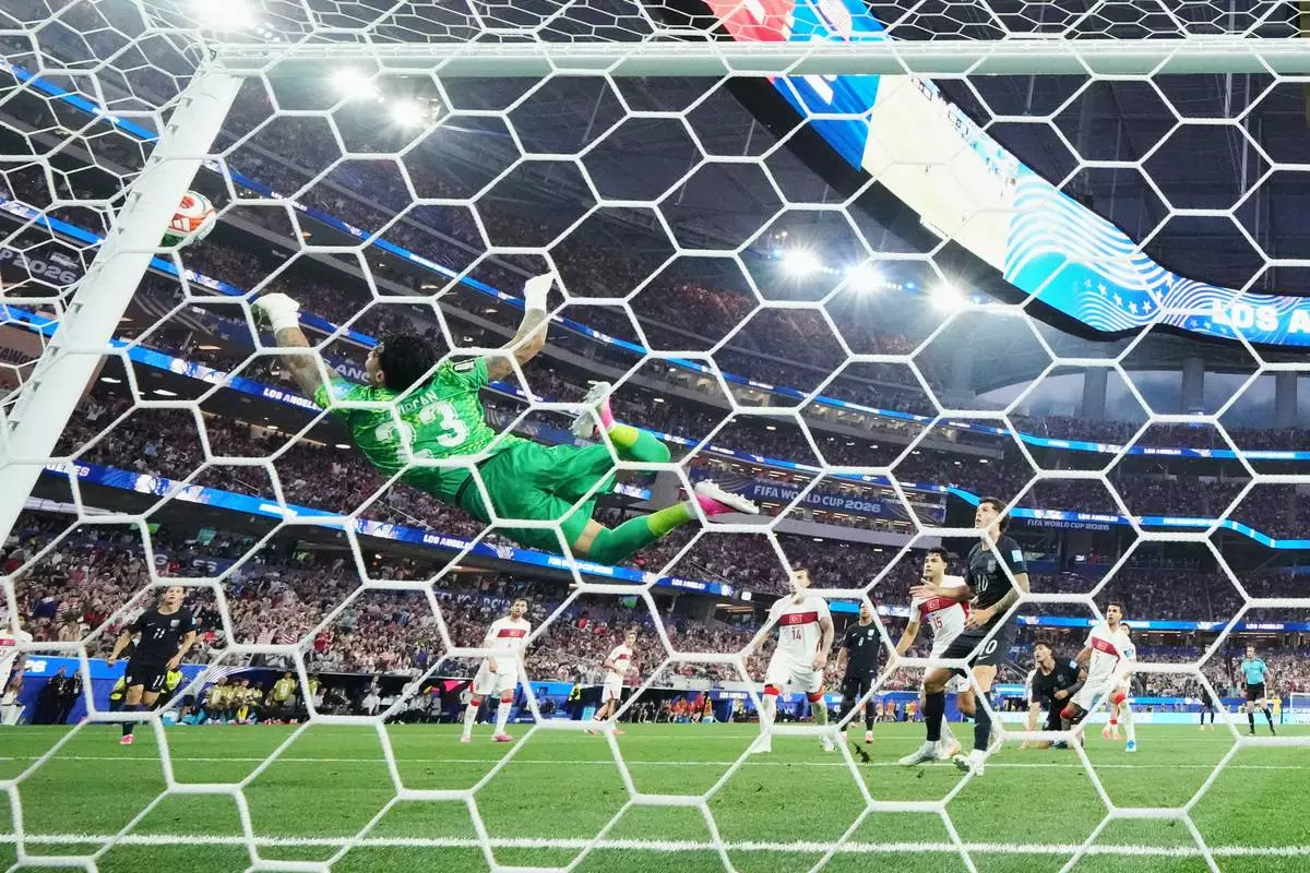 Turkey goalkeeper Ugurcan Cakir (23) makes a diving save on a shot by United States' Christian Pulisic (10) during the World Cup Group D soccer match between Turkey and the United States in Inglewood, Calif., near Los Angeles, Thursday, June 25, 2026. (AP Photo/Andre Penner) CORRECTON; Corrects ID to Turkey goalkeeper Ugurcan Cakir, not Tunisia's Moutaz Neffati.