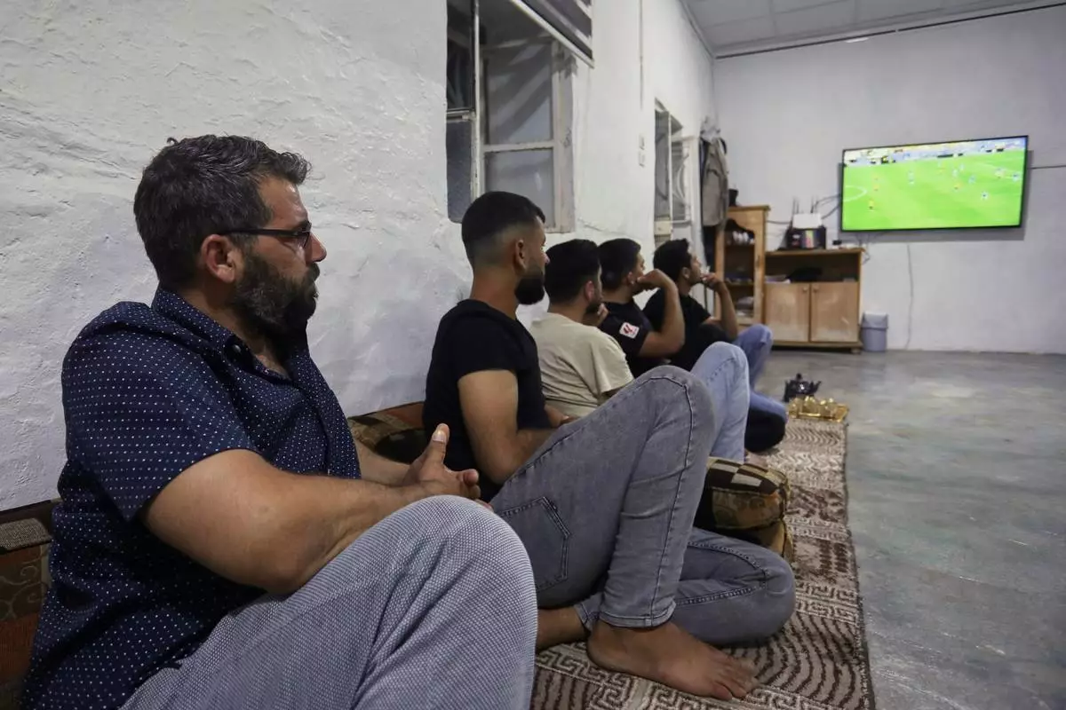 A small group of Yazidis gather to watch the Germany-Ecuador match at the home of community leader Ismail Dalaf in Khirbet al-Ghazal, northeastern Syria, late Thursday, June 25, 2026.(AP Photo/Hogir Al Abdo)