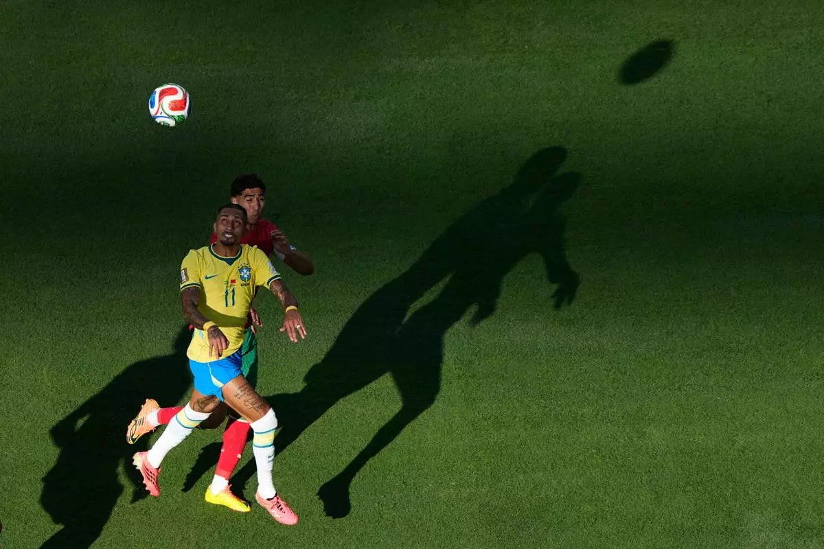 Brazil's Raphinha (11) and Morocco's Achraf Hakimi go up for a head ball during the World Cup Group C soccer match in East Rutherford, N.J., near New York, Saturday, June 13, 2026. (AP Photo/Matt Slocum)