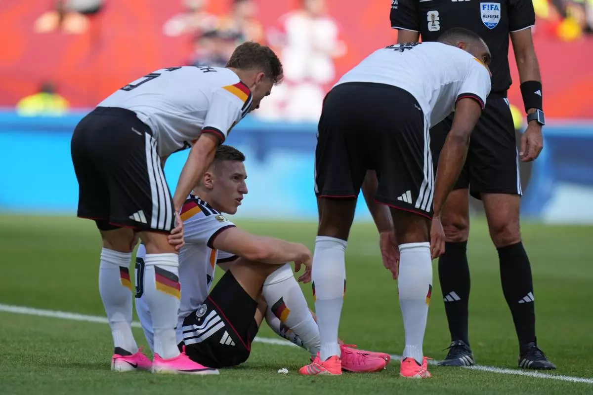 Germany's Nico Schlotterbeck, centre, waits to receive treatment following an injury during the World Cup Group E soccer match between Germany and Ivory Coast in Toronto, Saturday, June 20, 2026. (AP Photo/Stephanie Scarbrough)