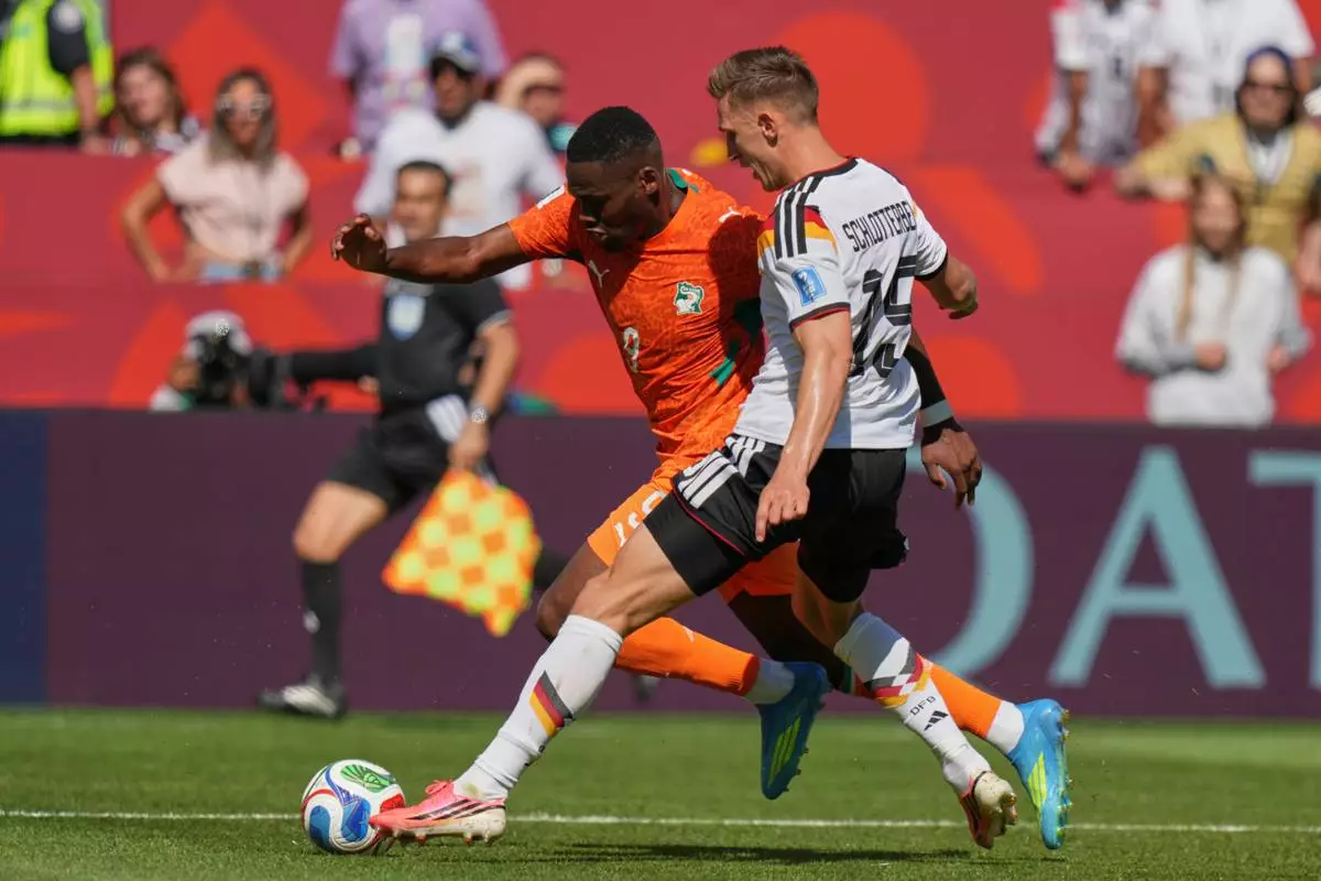 Germany's Nico Schlotterbeck, right, challenges Ivory Coast's Ange-Yoan Bonny for the ball during the World Cup Group E soccer match between Germany and Ivory Coast in Toronto, Saturday, June 20, 2026. (AP Photo/Stephanie Scarbrough)
