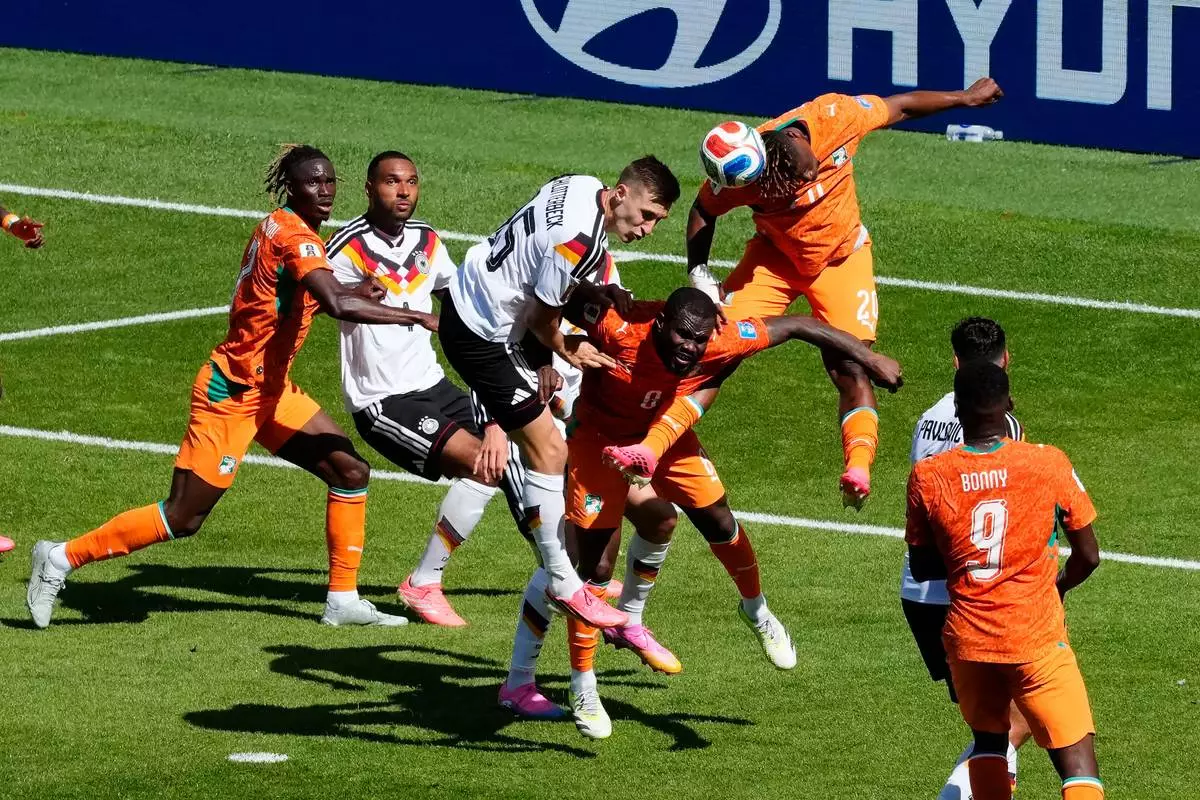 Germany's Nico Schlotterbeck (15) vies for a high ball with Ivory Coast's Emmanuel Agbadou (20) and Franck Kessie (8) during the World Cup Group E soccer match between Germany and Ivory Coast in Toronto, Saturday, June 20, 2026. (Chris Young/The Canadian Press via AP)