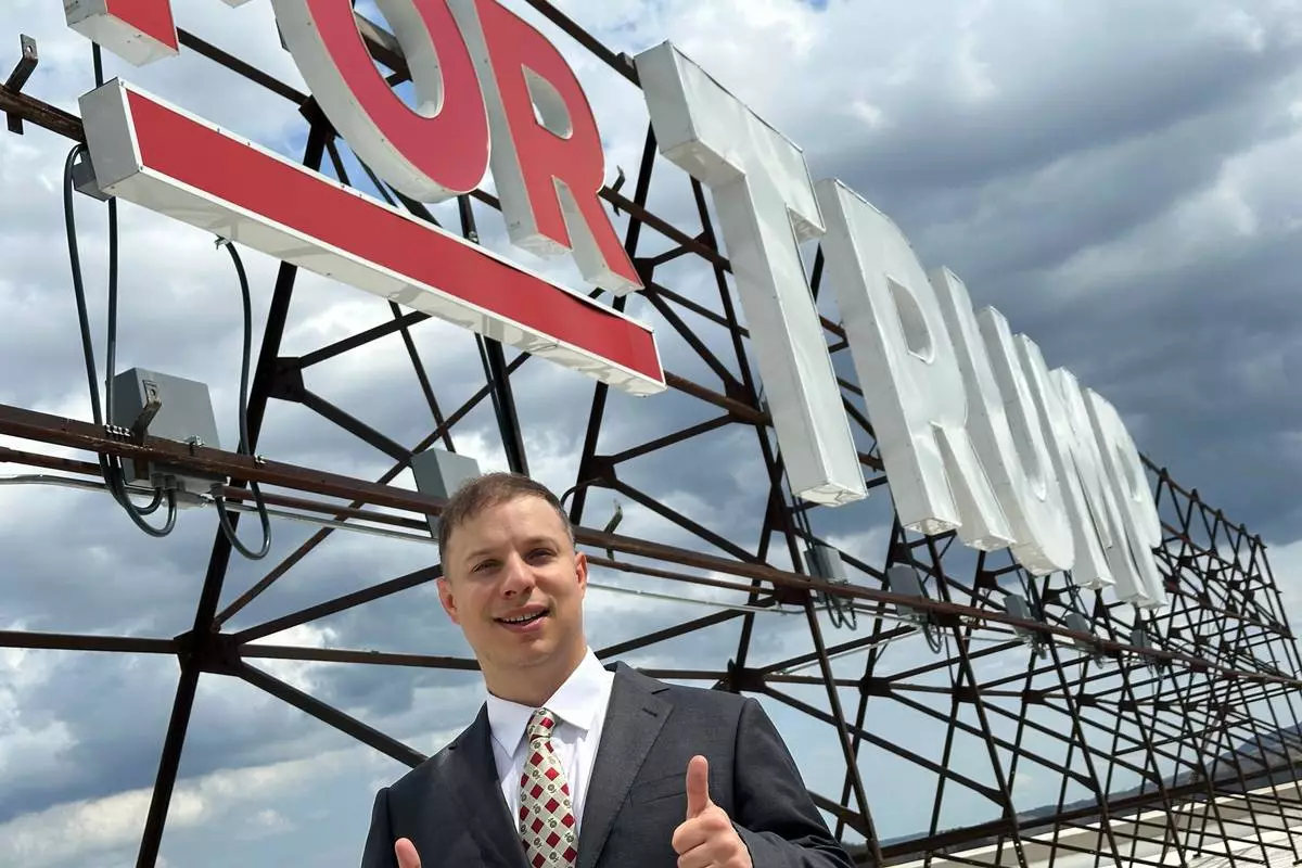 Anthony Constantino, a Republican candidate for Congress, stands next to the large "Vote for Trump" sign on the roof of his printing company, Sticker Mule, in Amsterdam, New York, Thursday, April 16, 2026. (AP Photo/Michael Hill)