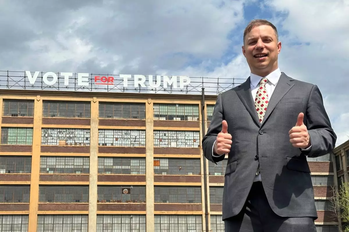 Anthony Constantino, a Republican candidate for Congress, stands in front of a "Vote for Trump" sign on the roof of his printing company, Sticker Mule, in Amsterdam, New York, Thursday, April 16, 2026. (AP Photo/Michael Hill)
