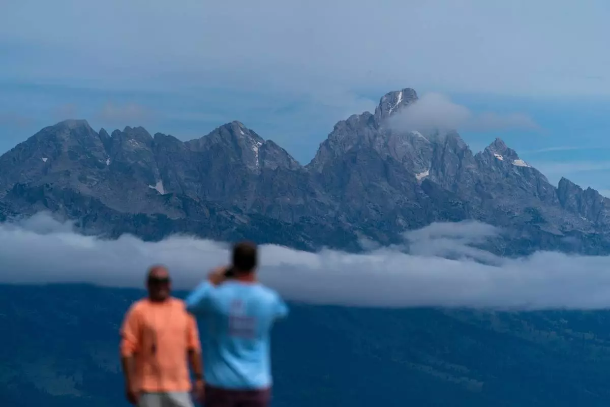 FILE - Tourists take photos in Grand Teton National Park, Wyo., Aug. 14, 2022. (AP Photo/Jae C. Hong, File)