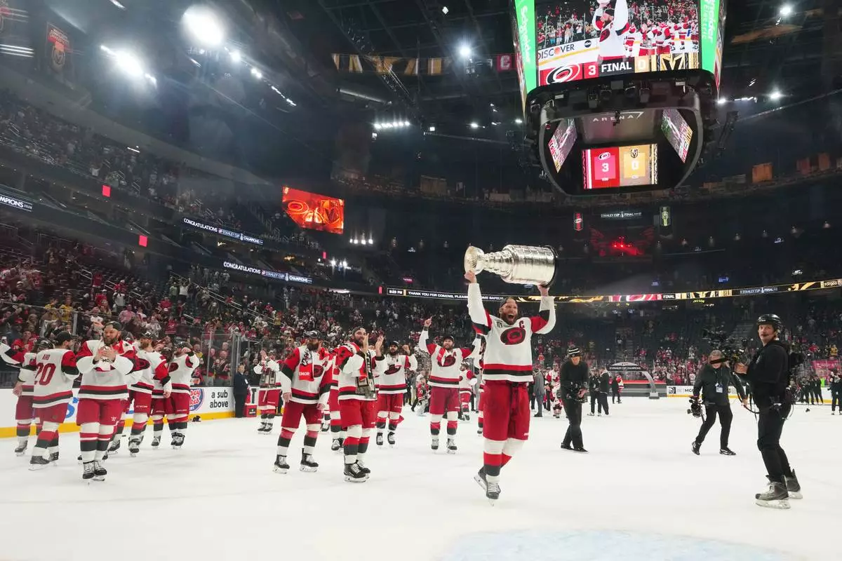 Carolina Hurricanes center Jordan Staal (11) lifts the Stanley Cup after a win over the Vegas Golden Knights in Game 6 of the NHL hockey Stanley Cup Final series, Sunday, June 14, 2026, in Las Vegas. (AP Photo/Candice Ward)