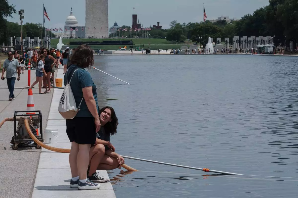 Visitors look at the Lincoln Memorial Reflecting Pool Sunday, June 21, 2026, on the National Mall in Washington. (AP Photo/Jon Elswick
