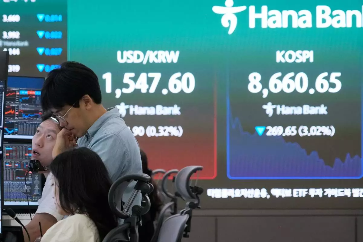 Currency traders work near a screen showing the Korea Composite Stock Price Index (KOSPI) and the foreign exchange rate between U.S. dollar and South Korean won at the foreign exchange dealing room of the Hana Bank headquarters in Seoul, South Korea, Friday, June 26, 2026. (AP Photo/Ahn Young-joon)