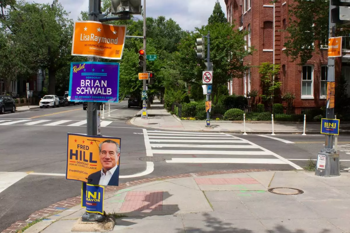 Campaign signs are posted on a lamp posts in the Logan Circle neighborhood of Washington, Sunday, June 7, 2026. (AP Photo/Tallulah Brown Van Zee)
