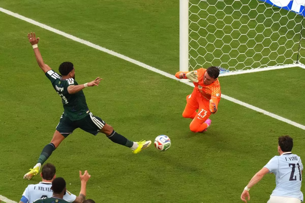 Saudi Arabia's Abdulelah Alamri (4) shoots and scores their opening goal against Uruguay goalkeeper Fernando Muslera (23) during the World Cup Group H soccer match between Saudi Arabia and Uruguay in Miami Gardens, Fla., Monday, June 15, 2026. (AP Photo/Marta Lavandier)