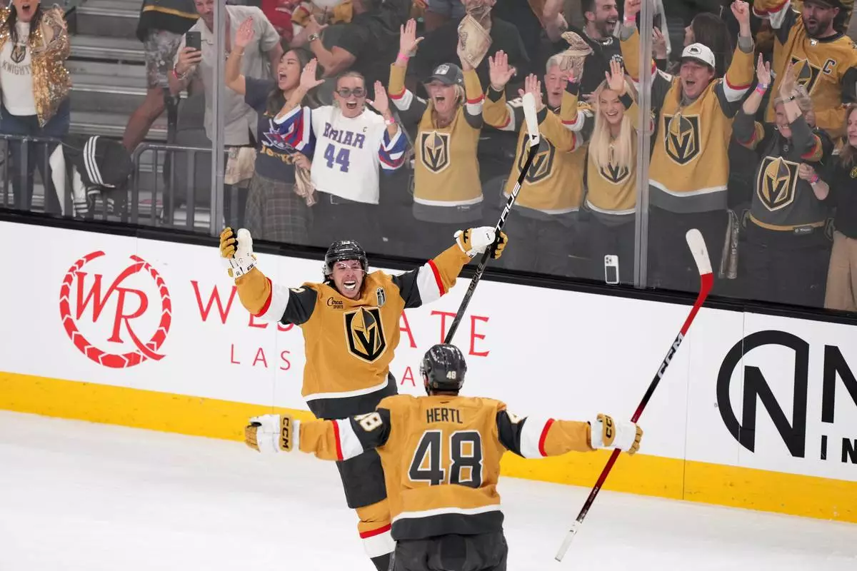 Vegas Golden Knights right wing Mitch Marner, top, celebrates his goal with center Tomas Hertl during the second period in Game 3 of the NHL hockey Stanley Cup Final series against the Carolina Hurricanes, Saturday, June 6, 2026, in Las Vegas. (AP Photo/Candice Ward)