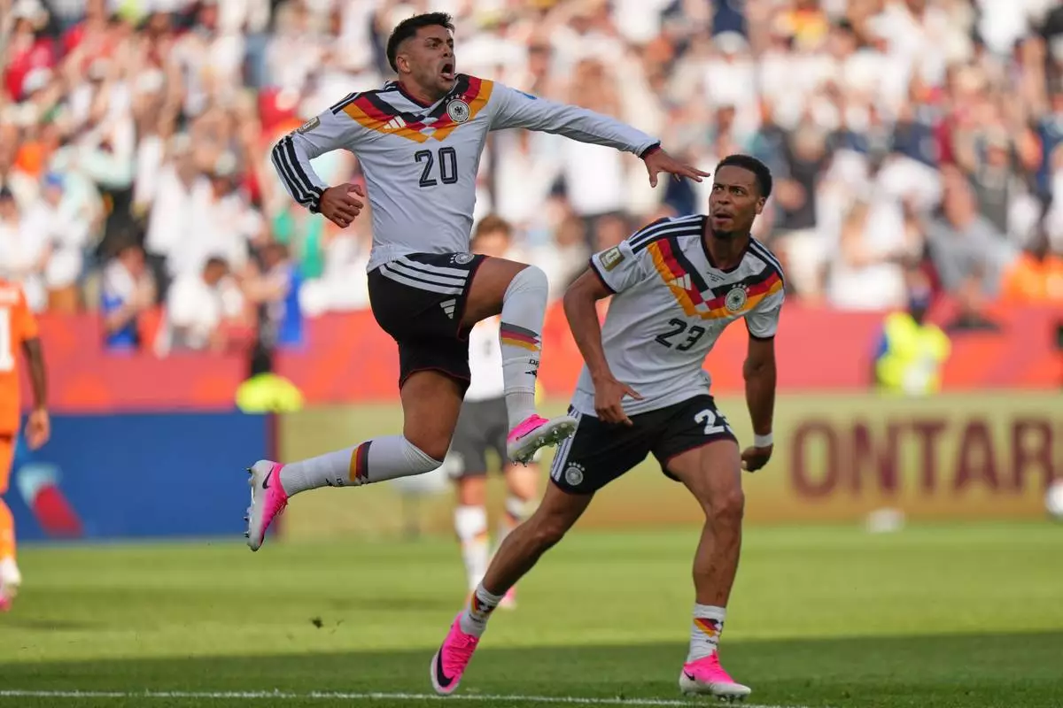 Germany's Nadiem Amiri leaps in the air as he celebrates after teammate Germany's Deniz Undav (26) scored their first goal during the World Cup Group E soccer match between Germany and Ivory Coast in Toronto, Saturday, June 20, 2026. (AP Photo/Stephanie Scarbrough)