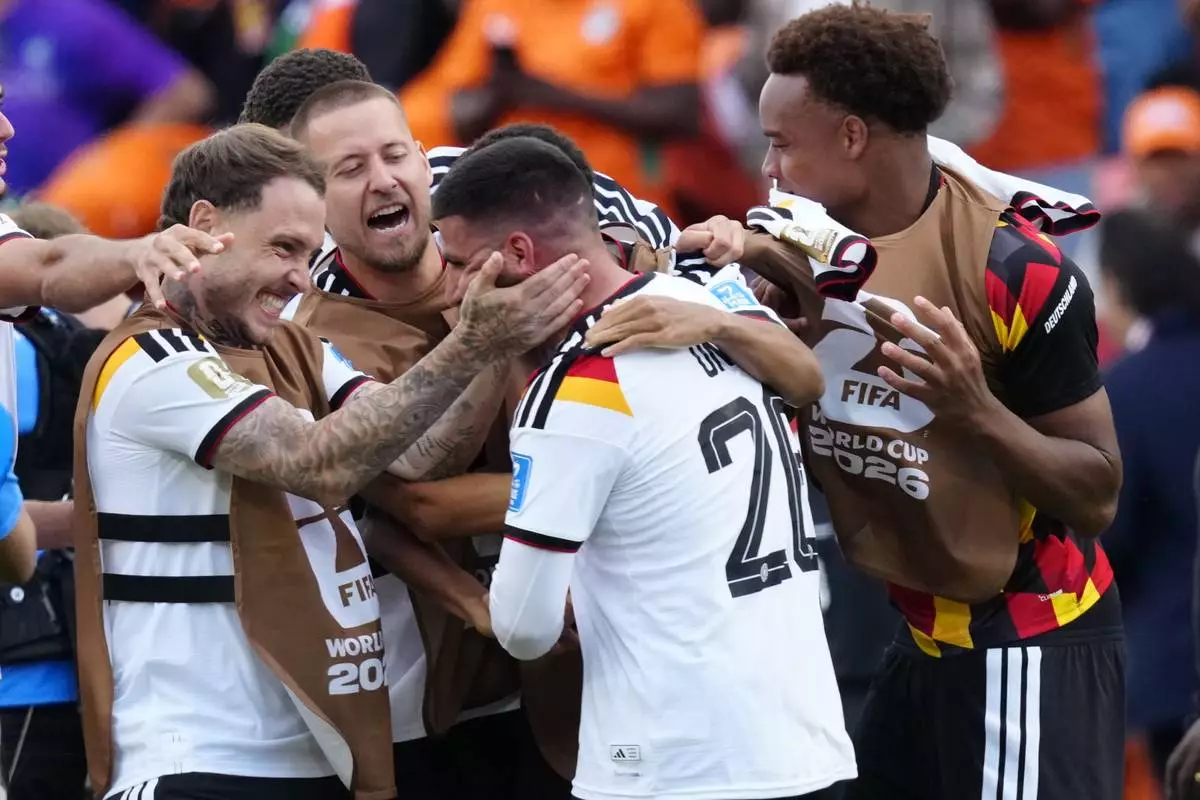 Germany's Deniz Undav (26) is mobbed by teammates after scoring their second goal during the World Cup Group E soccer match between Germany and Ivory Coast in Toronto, Saturday, June 20, 2026. (Frank Gunn/The Canadian Press via AP)