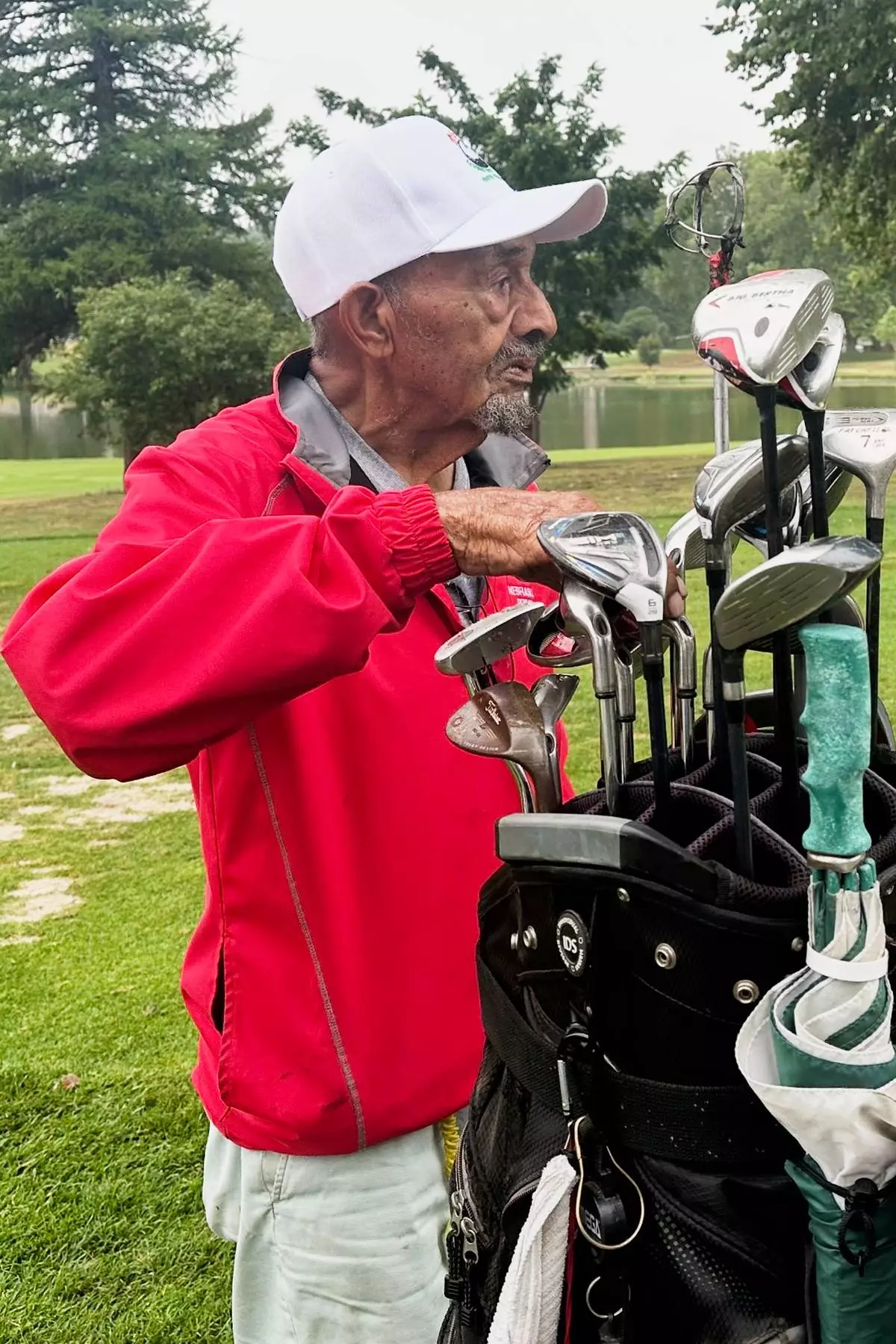 Bob Walls, a 103-year-old golfer, selects a club on the third hole at Steve Hogan Golf Course in Omaha, Neb., Friday, July 24, 2026. (AP Photo/Eric Olson)