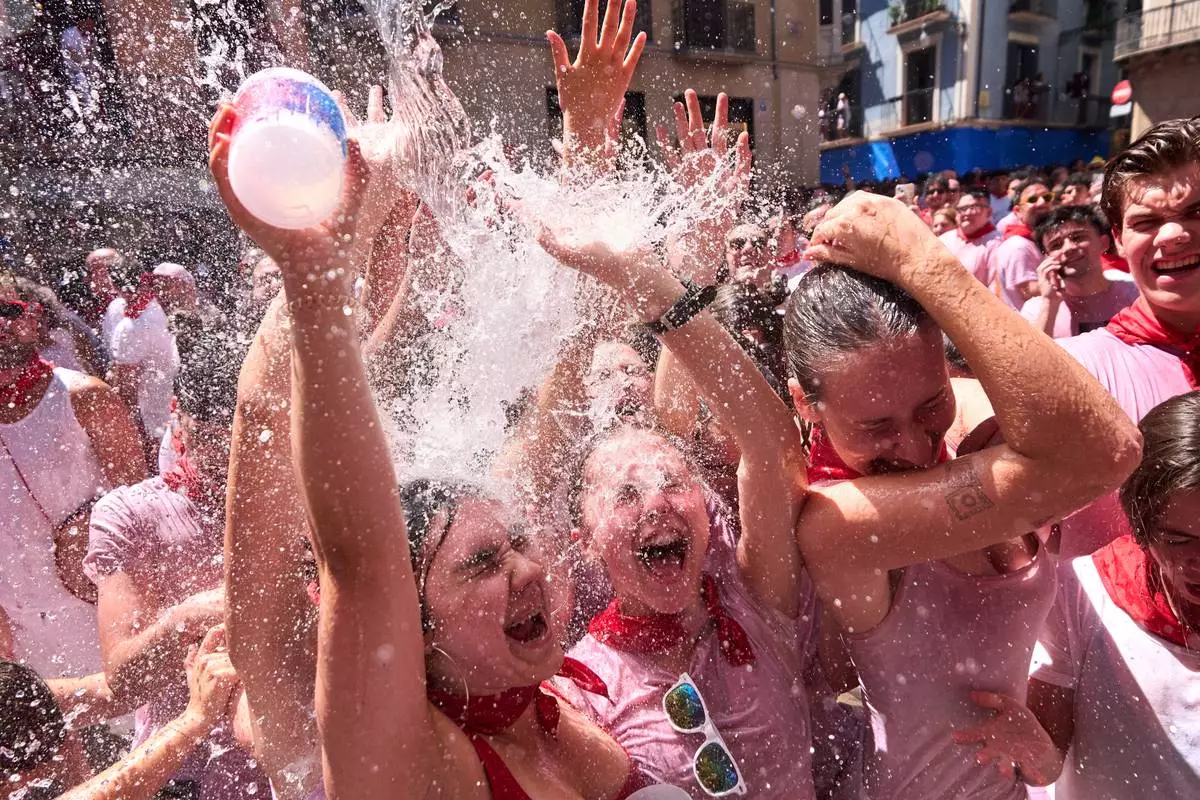 Revelers celebrate as the txupinazo, the traditional rocket marking the start of the San Fermín festival, kicks off nine days of uninterrupted festivities in Pamplona, Spain, Monday, July 6, 2026. (AP Photo/Miguel Oses)