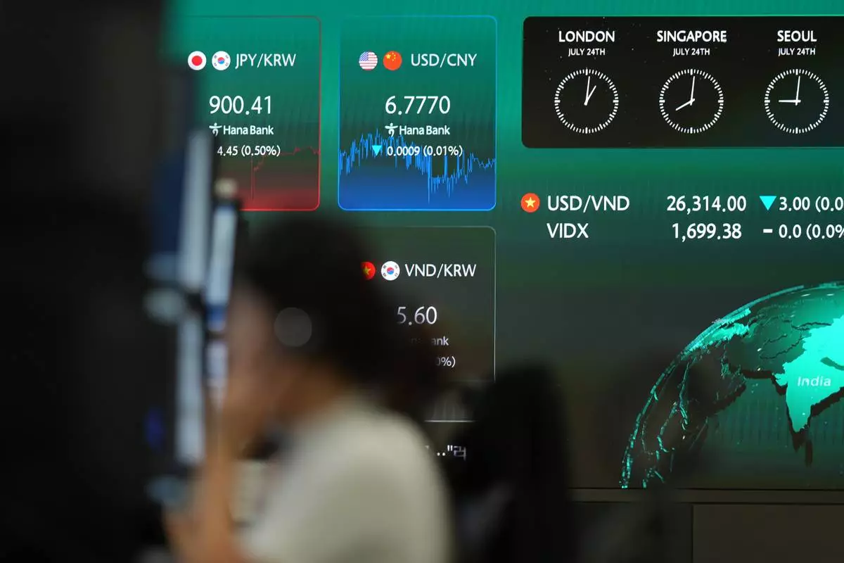 A dealer talks on the phone near the screens showing the foreign exchange rates at a dealing room of Hana Bank in Seoul, South Korea, Friday, July 24, 2026. (AP Photo/Lee Jin-man)