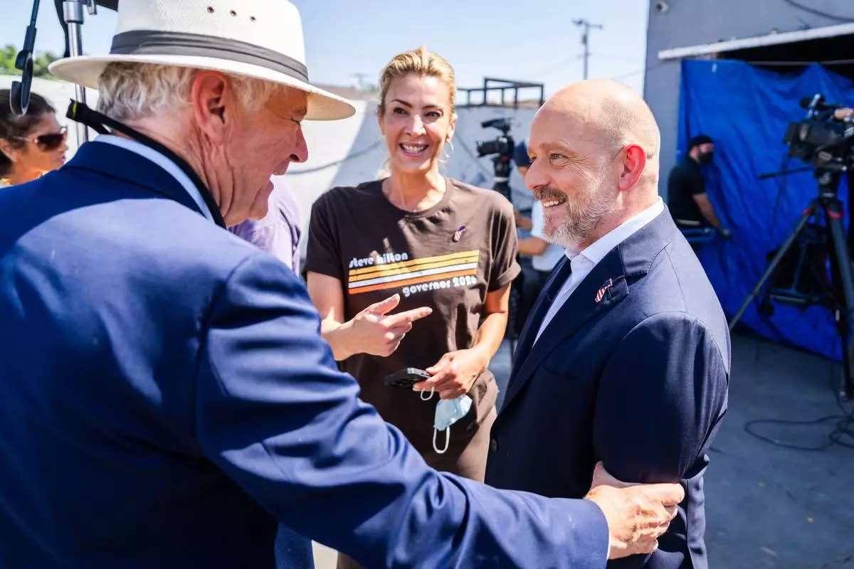 California Republican gubernatorial candidate Steve Hilton, right, talks to people after a campaign event on Wednesday, July 22, 2026, in Los Angeles. (AP Photo/Ethan Swope)