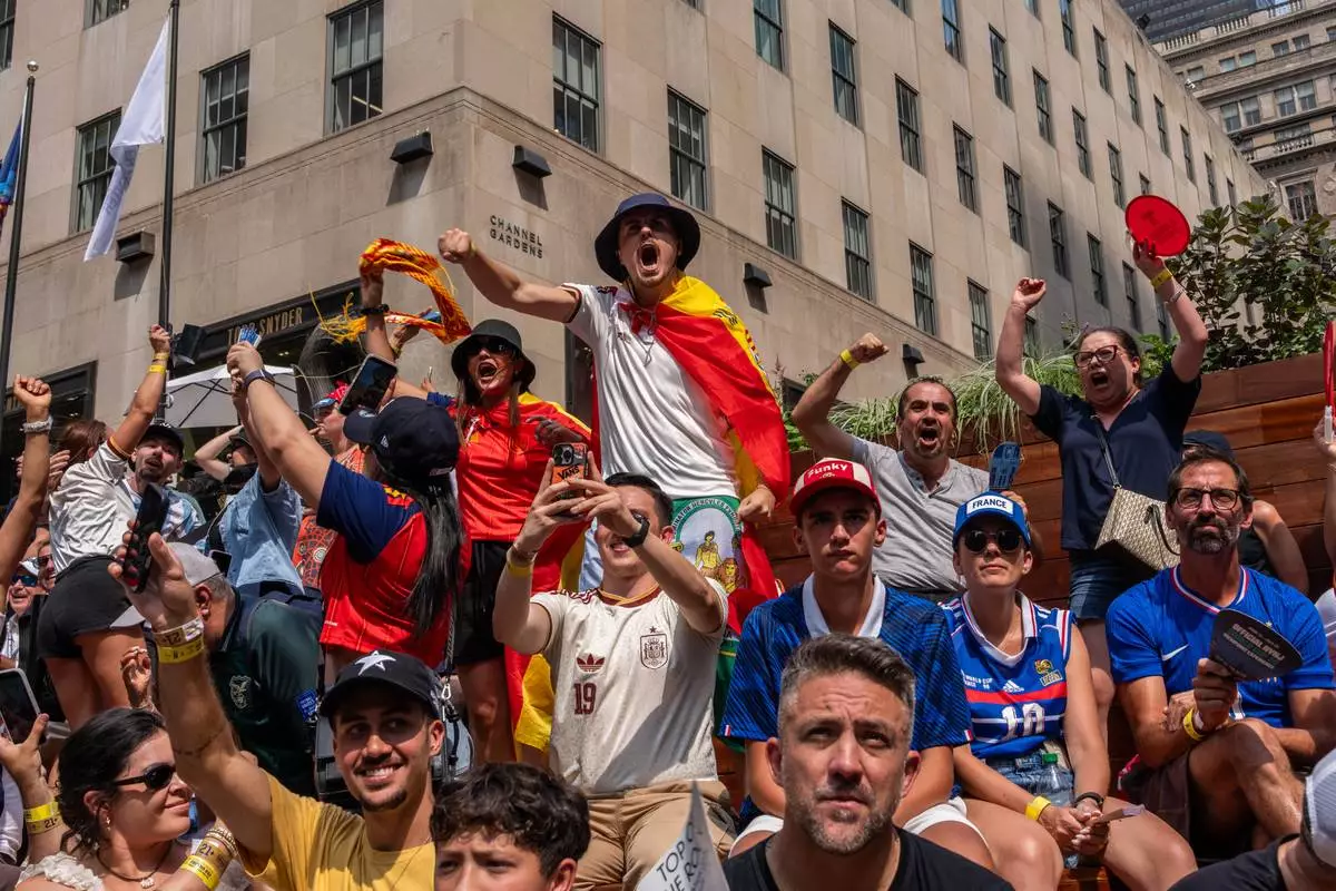 Spain fan reacts after the team scored their first goal during the World Cup semifinal soccer match between Spain and France at a watch party at the Rockefeller Center fan village, Tuesday, July 14, 2026, in New York. (AP Photo/Adam Gray)