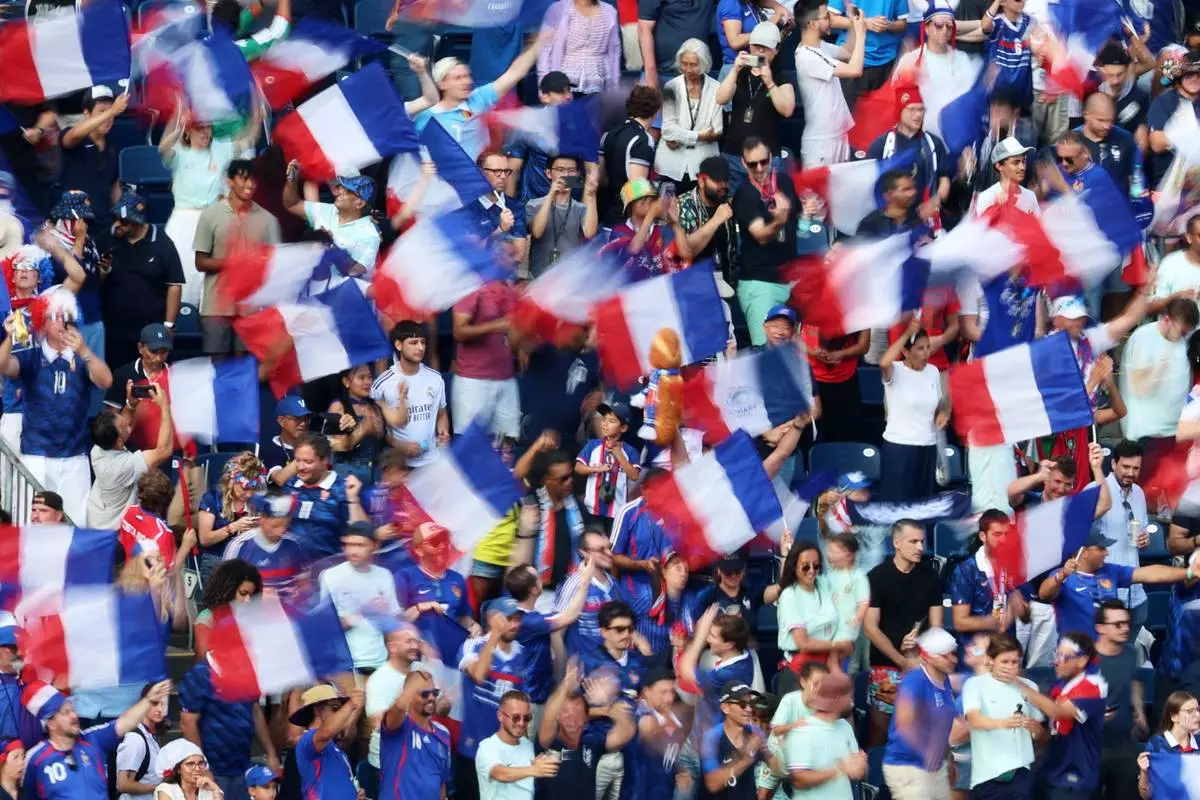 In this photo taken with slow shutter speed, fans celebrate as France defeats Morocco during the World Cup quarterfinal soccer match in Foxborough, Mass., near Boston, Thursday, July 9, 2026. (AP Photo/Mark Stockwell)