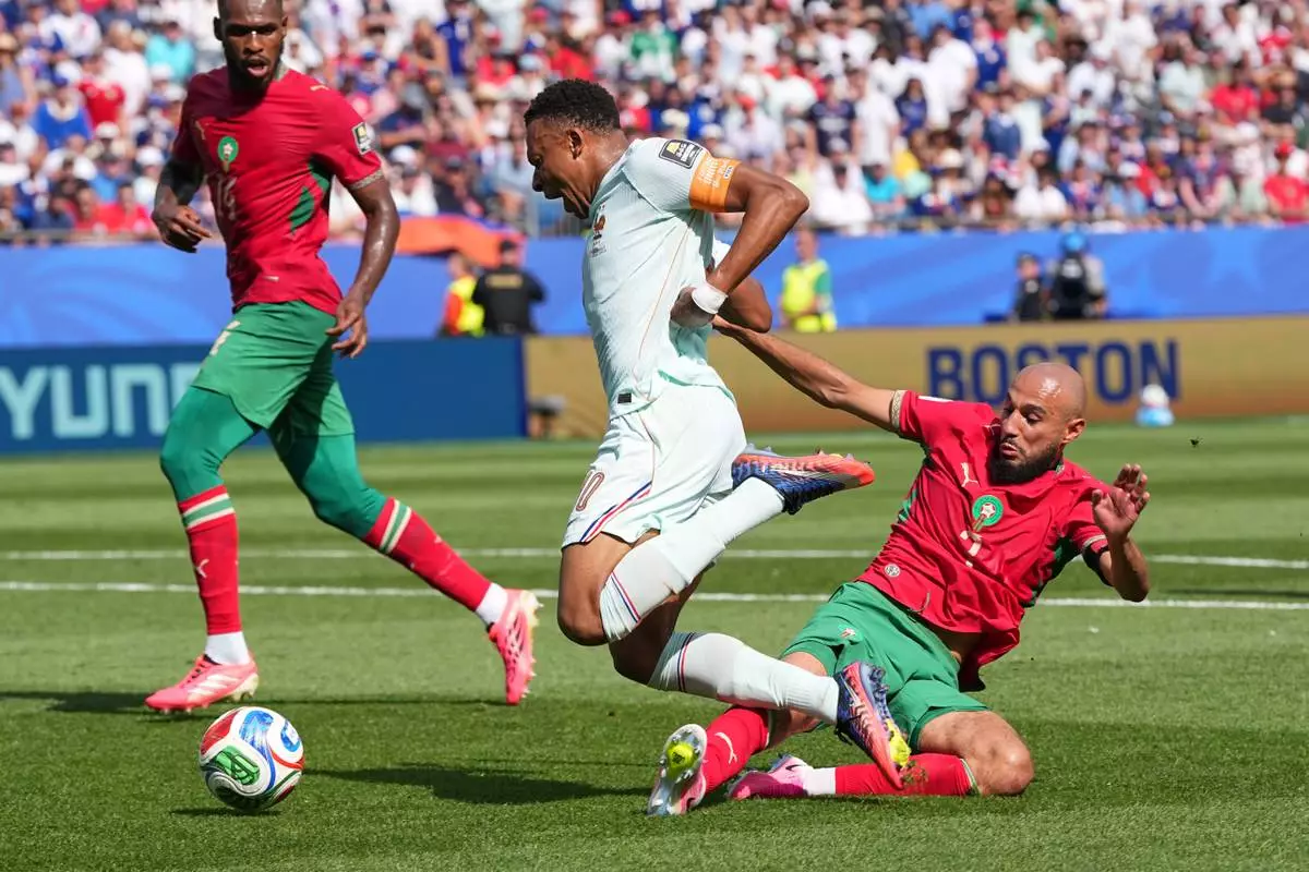France's Kylian Mbappe (10) is fouled by Morocco's Noussair Mazraoui (3) during the World Cup quarterfinal soccer match between France and Morocco in Foxborough, Mass., near Boston, Thursday, July 9, 2026. (AP Photo/Martin Meissner)