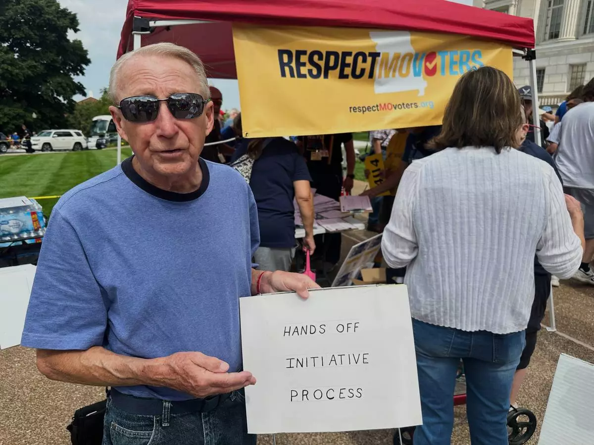 FILE - John Billman, of Columbia, Mo., holds a sign explaining his opposition to a state legislative proposal that would make it harder for voters to approve citizen-initiated constitutional amendments while rallying at the state Capitol in Jefferson City, on Wednesday, Sept. 10, 2025. (AP Photo/David A. Lieb, File)