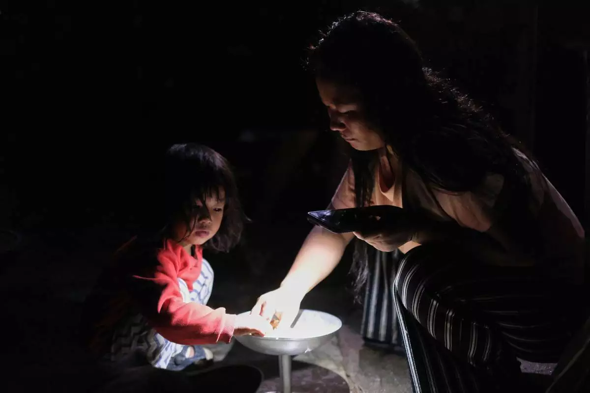 Atoshi Ayemi eats dinner with her daughter Azatina Murru inside their kitchen in Kohima, capital of the northeastern Indian state of Nagaland, Monday, July 6, 2026. (AP Photo/Yirmiyan Arthur)