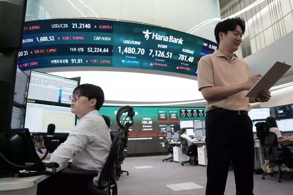 Currency traders work at the foreign exchange dealing room of the Hana Bank headquarters in Seoul, South Korea, Wednesday, July 22, 2026. (AP Photo/Ahn Young-joon)