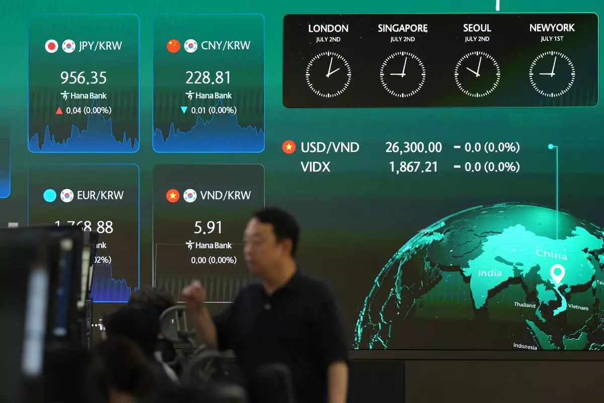 A dealer walks past near the screens showing the foreign exchange rates at a dealing room of Hana Bank in Seoul, South Korea, Thursday, July 2, 2026. (AP Photo/Lee Jin-man)