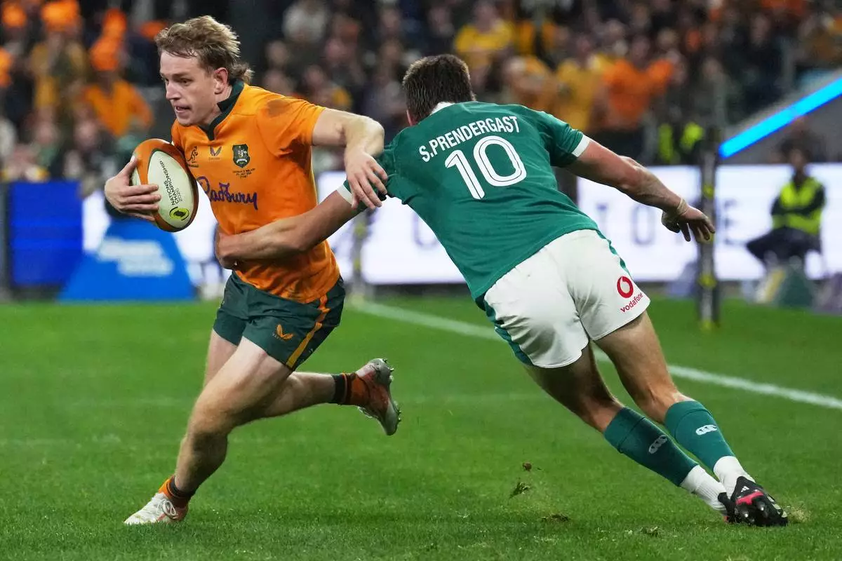 Australia's Max Jorgensen tries to evade the tackle of Ireland's Sam Prendergast during the Nations Championship rugby international between Australia and Ireland in Sydney, Saturday July, 4, 2026. CORRECTION: corrects ID to Australia's Max Jorgensen to replace Joseph-Aukuso Suaalii (AP Photo/Mark Baker)